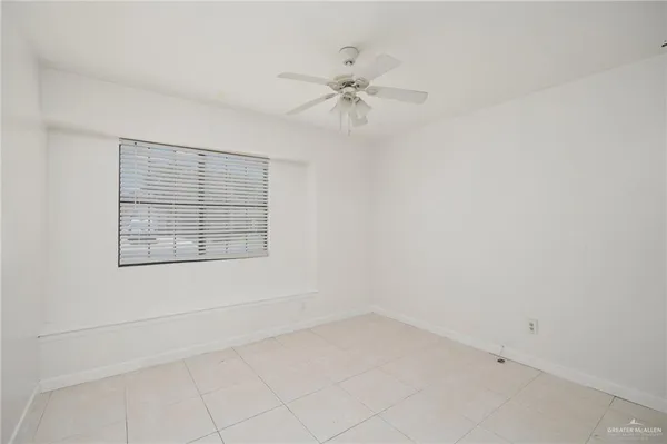 an empty room with a window and a fan