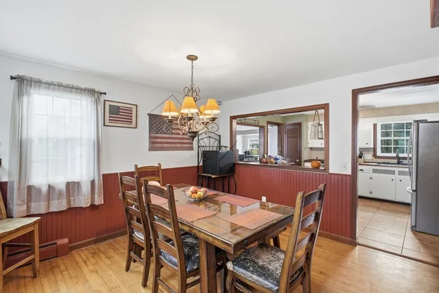 a view of a dining room with furniture a chandelier and wooden floor