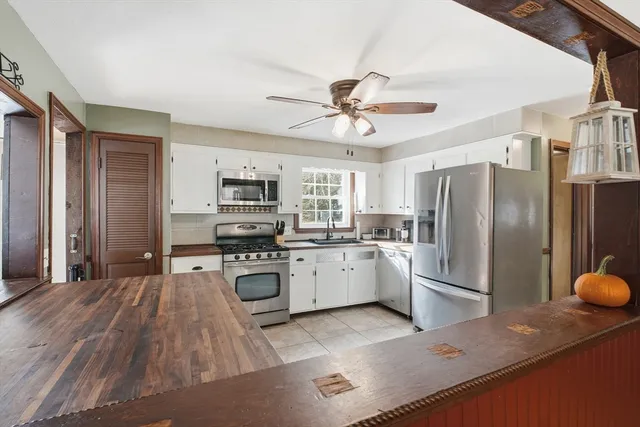 a kitchen with stainless steel appliances granite countertop a refrigerator a stove oven a sink dishwasher with a dining table and chairs