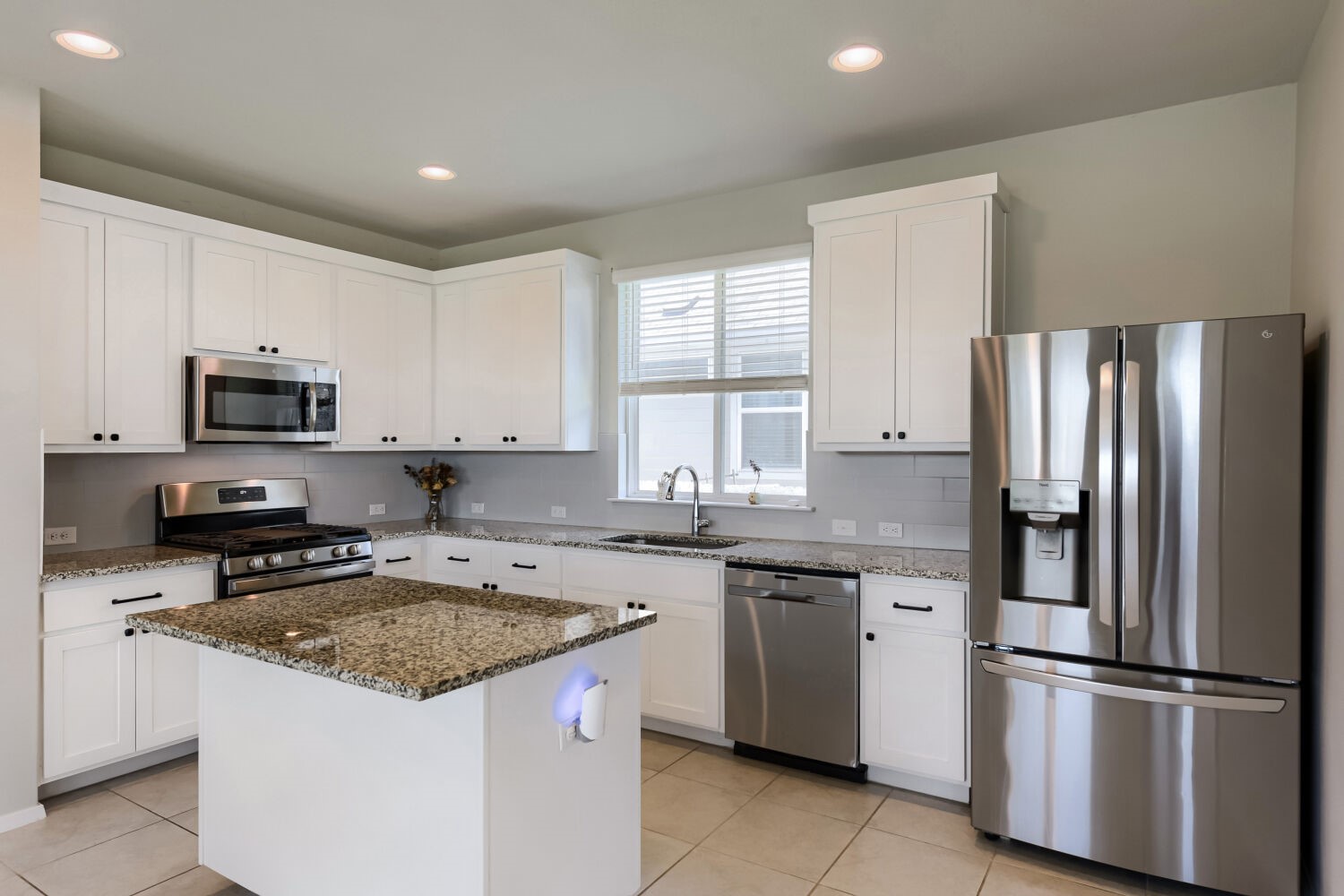 1310 Goforth Road Kyle, TX 78640 - Photo 10 of 24 Kitchen featuring white cabinetry, granite countertops, stainless steel appliances, a tiled backsplash, and recessed lighting