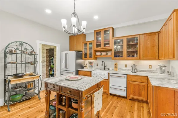 a kitchen that has a lot of cabinets stainless steel appliances and wooden floor