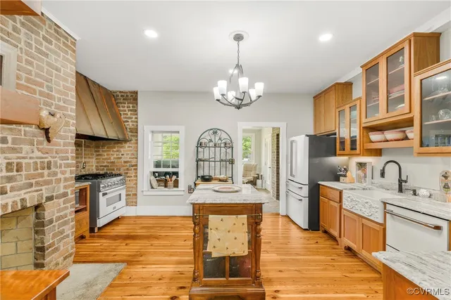 a large kitchen with stainless steel appliances granite countertop a stove refrigerator and cabinets