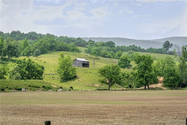 an aerial view of a houses with outdoor space and trees all around