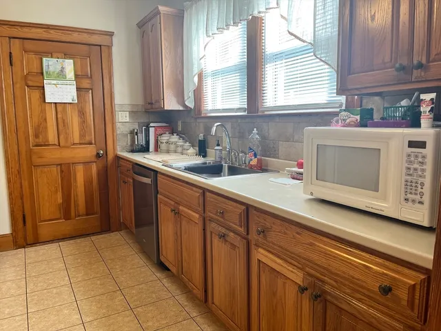 a kitchen with stainless steel appliances a sink cabinets and a window
