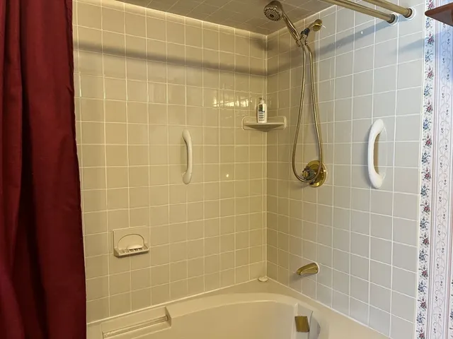 a spacious bedroom with a bed and a dresser