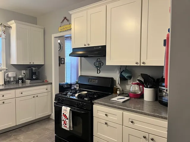 a kitchen with stainless steel appliances granite countertop a stove a sink and cabinets