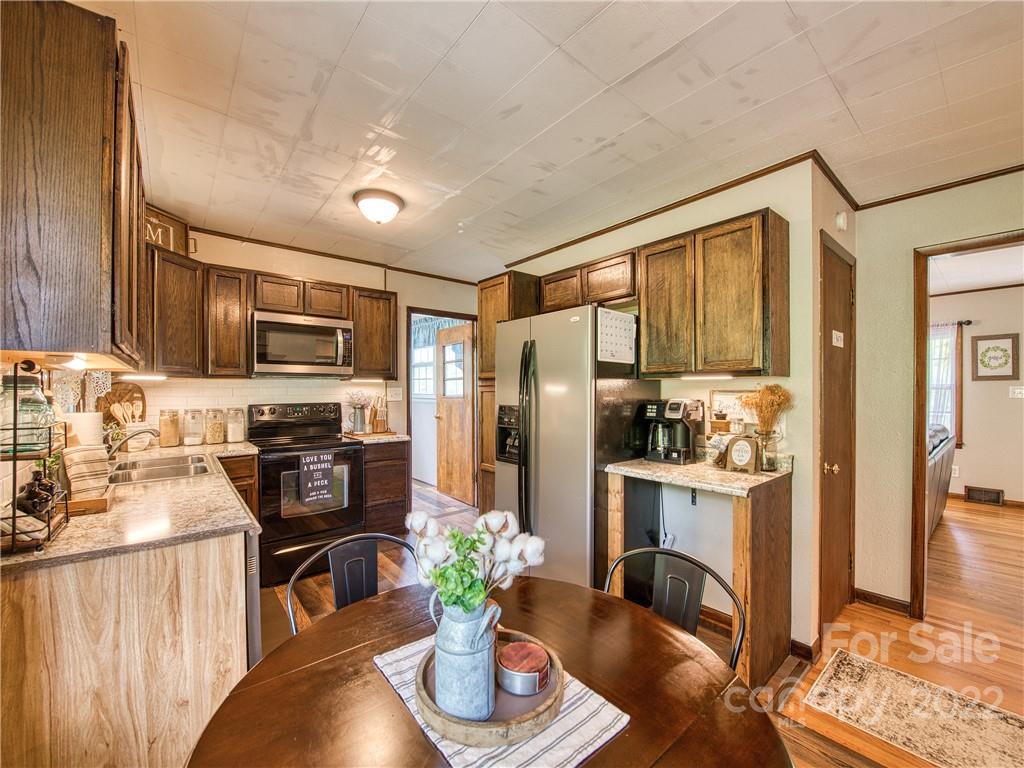 1239 Beaverdam Road Canton, NC 28716 - Photo 23 of 30 a kitchen with stainless steel appliances granite countertop a refrigerator a stove top oven a sink dishwasher and cabinets