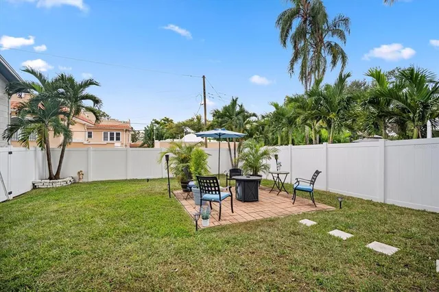 a front view of a house with a yard and potted plants