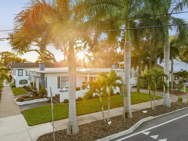 a front view of house with yard and trees in the background