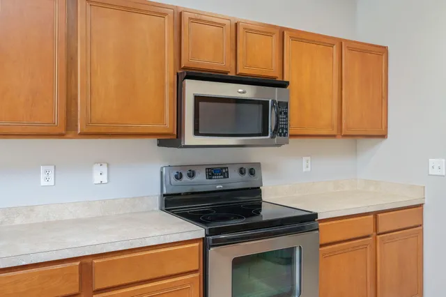 a kitchen with stainless steel appliances granite countertop white cabinets and a stove top oven with granite countertops
