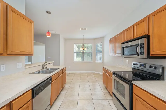 a kitchen with stainless steel appliances granite countertop a sink and a microwave
