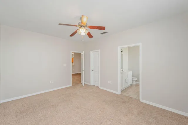 a view of a room with a ceiling fan and window