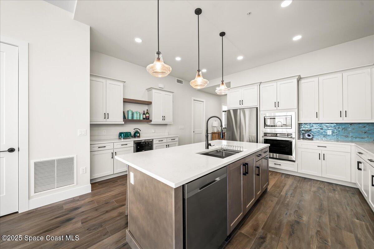 225 Strand Drive, Unit 401 Melbourne Beach, FL 32951 - Photo 12 of 51 a large kitchen with stainless steel appliances kitchen island a large island in the center