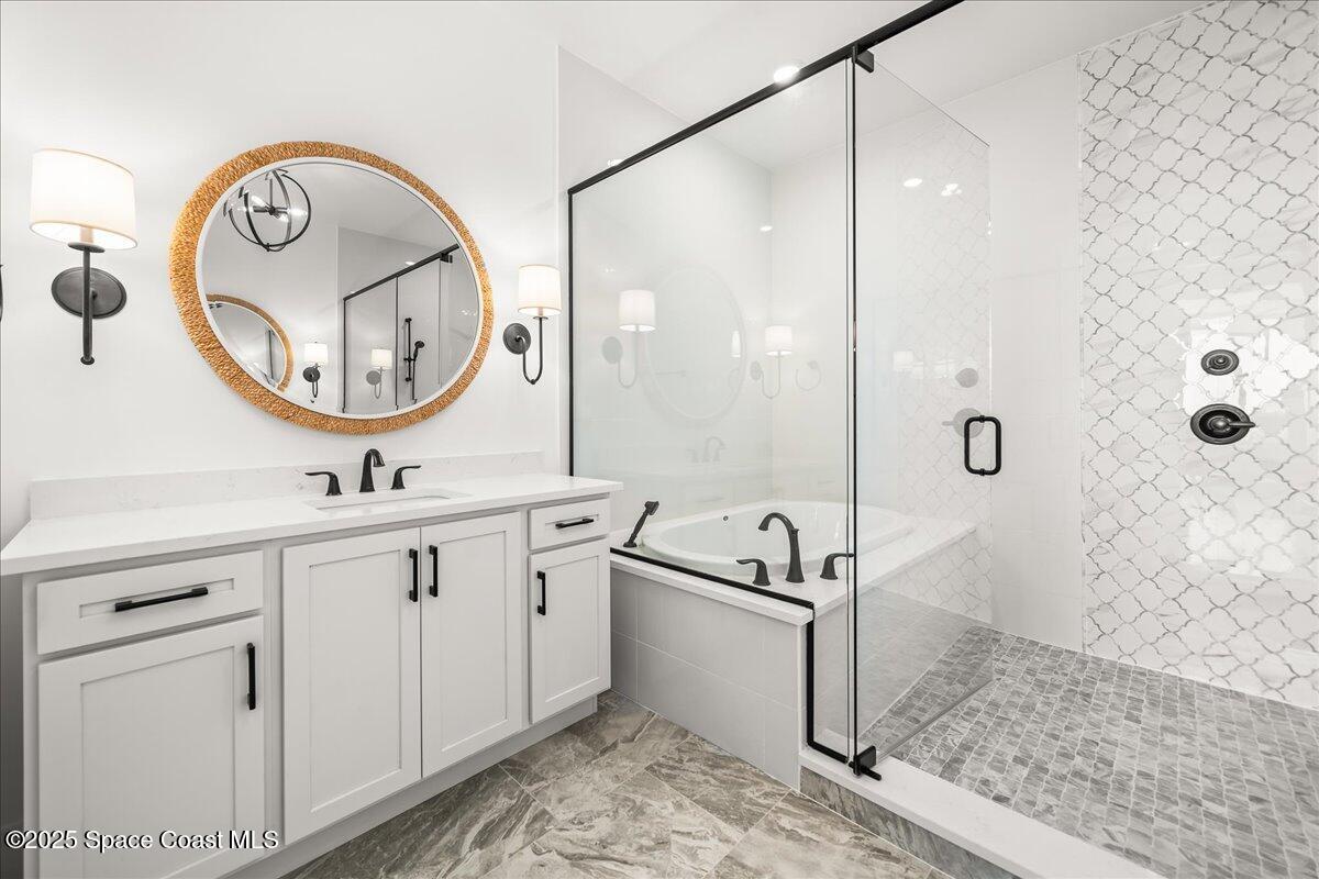 225 Strand Drive, Unit 401 Melbourne Beach, FL 32951 - Photo 23 of 51 a bathroom with a double vanity sink mirror and shower