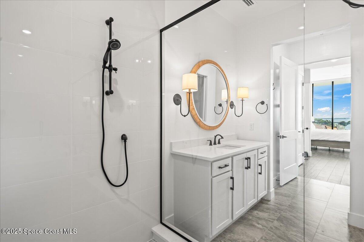 225 Strand Drive, Unit 401 Melbourne Beach, FL 32951 - Photo 24 of 51 a bathroom with a granite countertop sink mirror and a shower
