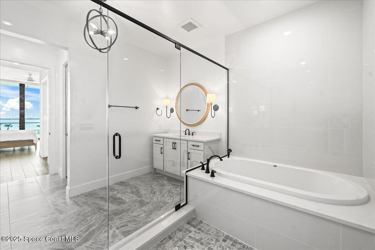 225 Strand Drive, Unit 401 Melbourne Beach, FL 32951 - Photo 25 of 51 a bathroom with a bathtub a sink a toilet and a shower