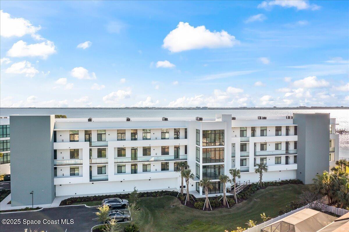 225 Strand Drive, Unit 401 Melbourne Beach, FL 32951 - Photo 35 of 51 a front view of a building with swimming pool and outdoor seating