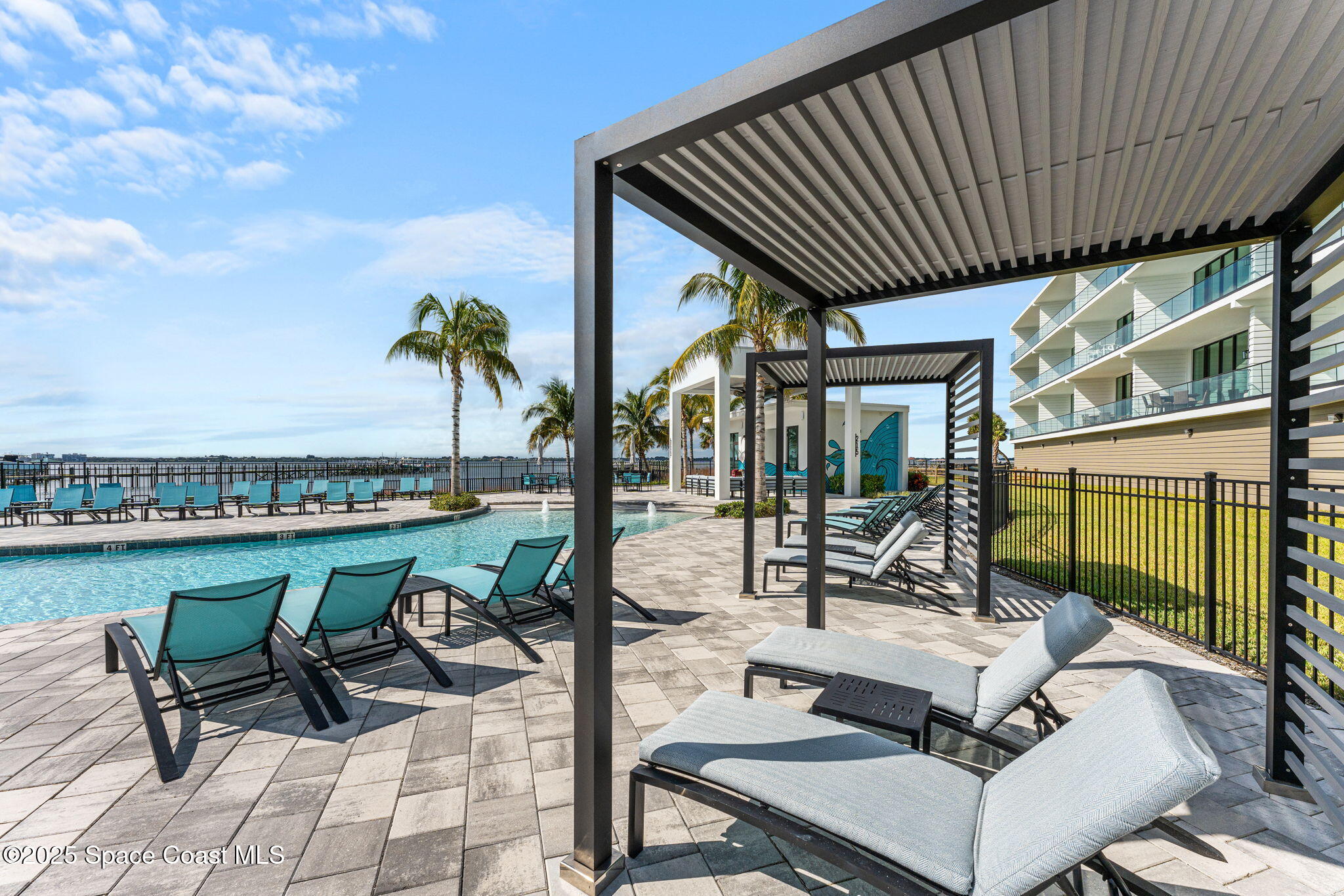 225 Strand Drive, Unit 401 Melbourne Beach, FL 32951 - Photo 40 of 51 a view of a patio with couches table and chairs with swimming pool and ocean view