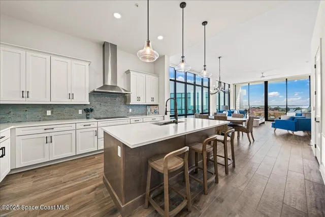 a open kitchen with stainless steel appliances granite countertop a kitchen island a stove a sink a table and chairs