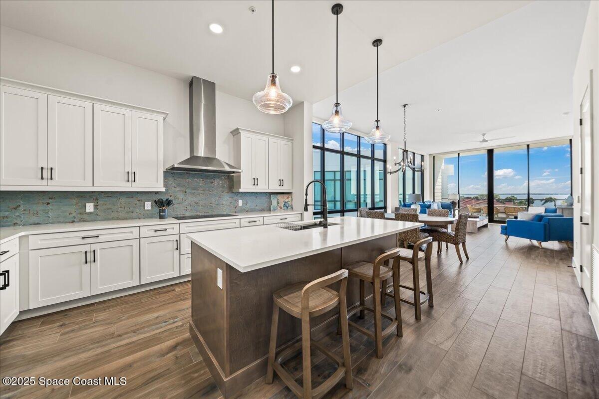 225 Strand Drive, Unit 401 Melbourne Beach, FL 32951 - Photo 6 of 51 a open kitchen with stainless steel appliances granite countertop a kitchen island a stove a sink a table and chairs