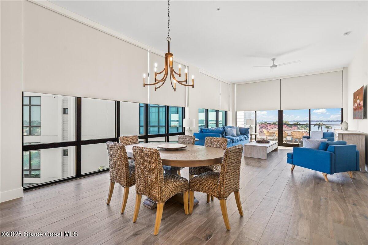 225 Strand Drive, Unit 401 Melbourne Beach, FL 32951 - Photo 10 of 51 a dining room with furniture a chandelier and wooden floor