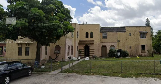a couple of cars parked in front of a house