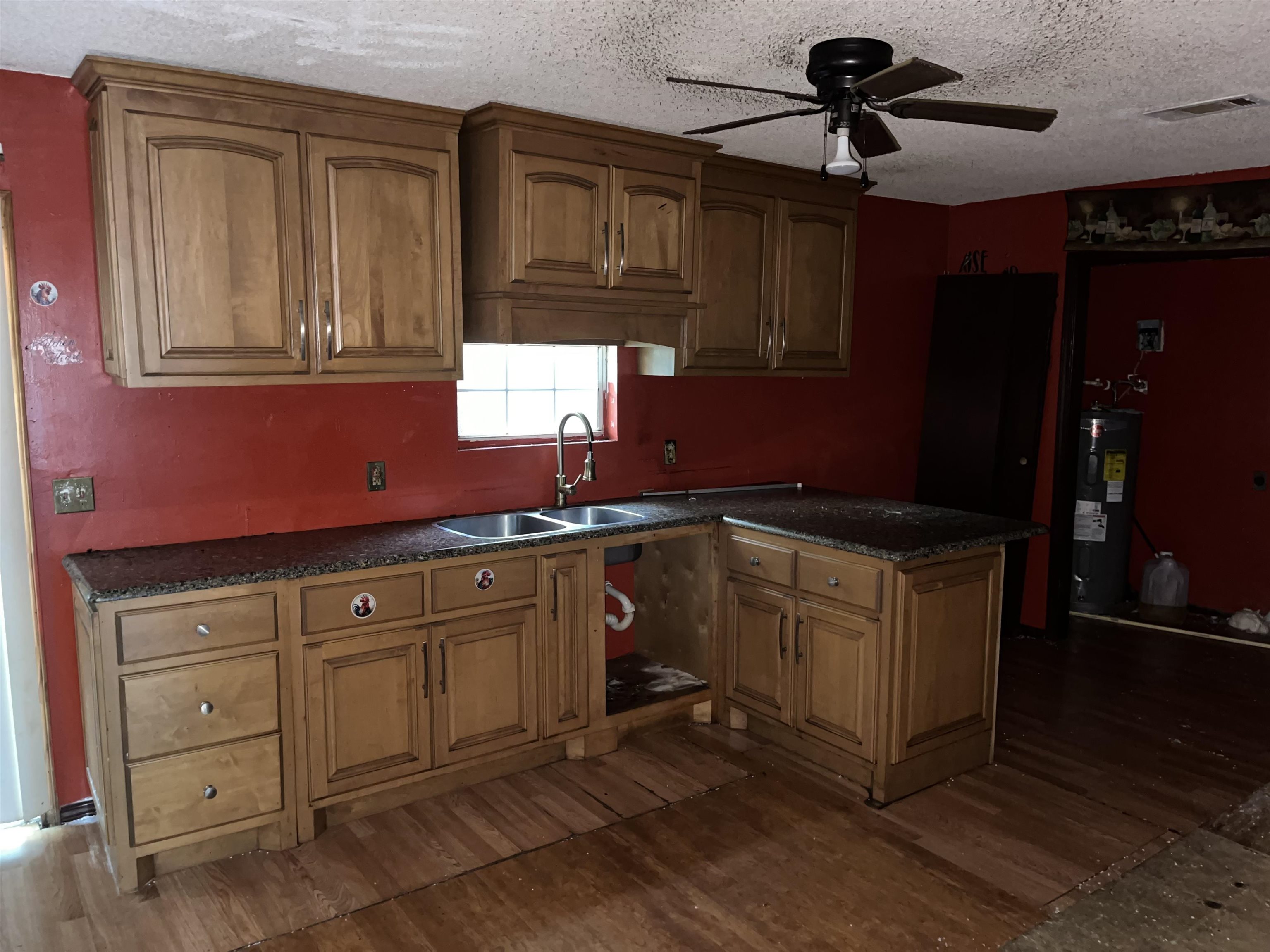 1685 Turner Road Grand Junction, TN 38039 - Photo 15 of 15 Kitchen featuring wood-finish cabinetry, dark granite-style countertops, double basin sink with a high-arch faucet, and a ceiling fan with integrated lighting