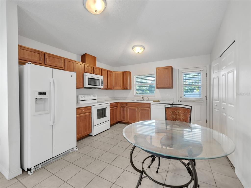 3509 King George Lane Seffner, FL 33584 - Photo 24 of 39 a kitchen with stainless steel appliances granite countertop a sink a stove a refrigerator with a dining table and chairs