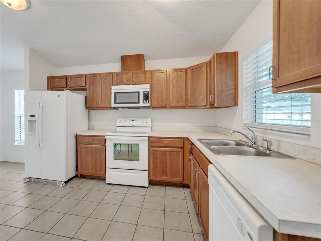 3509 King George Lane Seffner, FL 33584 - Photo 25 of 39 a kitchen with a stove a sink and a refrigerator