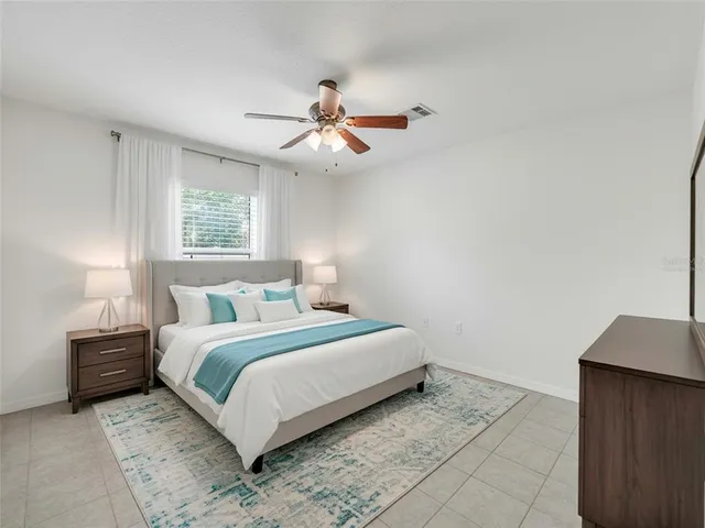 a bedroom with a bed and a ceiling fan