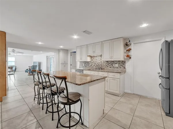 a kitchen with stainless steel appliances granite countertop a sink and a refrigerator