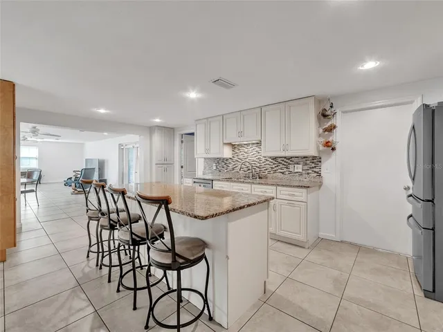 a kitchen with stainless steel appliances granite countertop a sink and a refrigerator