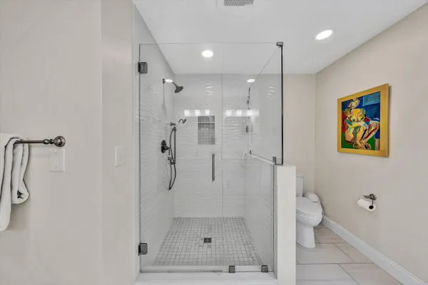 a spacious bathroom with a granite countertop sink a toilet a mirror and shower