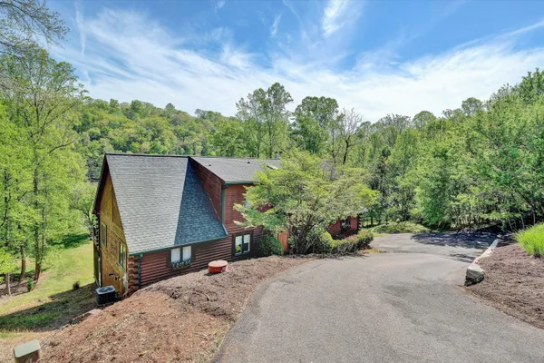 a view of house with yard and sitting area
