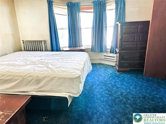 a spacious bedroom with a bed and a window