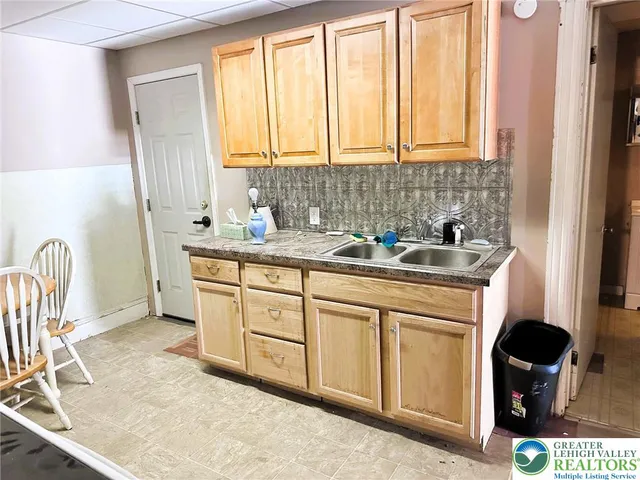 a kitchen with a sink a stove cabinets and a window