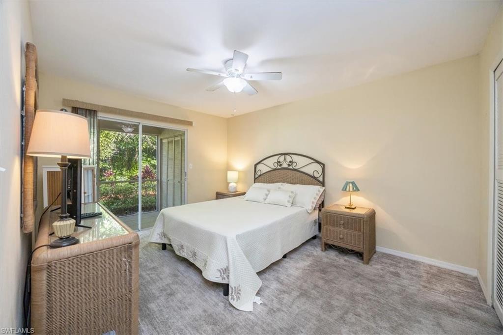 338 Bradstrom Circle, Unit 102 Naples, FL 34113 - Photo 11 of 21 a bedroom with a bed and a chandelier