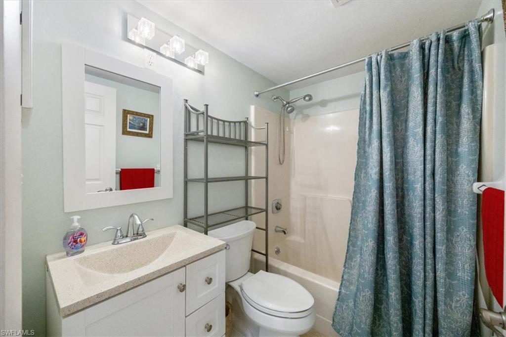 338 Bradstrom Circle, Unit 102 Naples, FL 34113 - Photo 15 of 21 a bathroom with a sink toilet vanity and shower