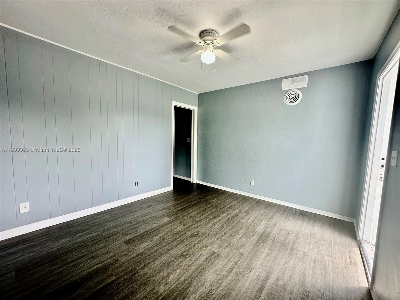 1260 Northeast 115th Street, Unit 2 Miami, FL 33161 - Photo 6 of 9 an empty room with wooden floor and fan