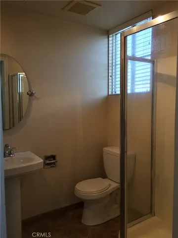 a bathroom with a toilet a sink and mirror