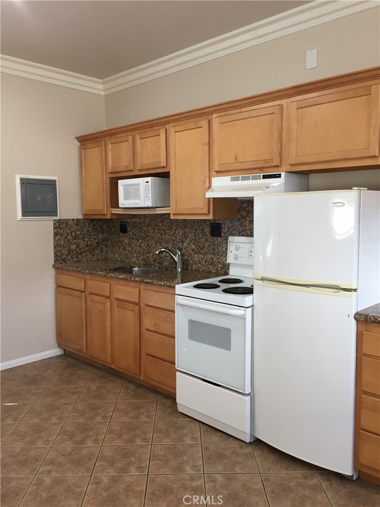 708 Delaware Street, Unit A Huntington Beach, CA 92648 - Photo 7 of 13 a kitchen with a stove a sink and a refrigerator