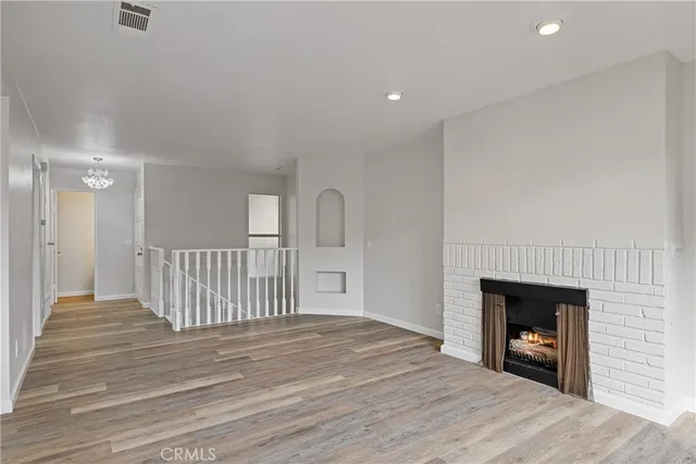 a view of a livingroom with wooden floor and a fireplace