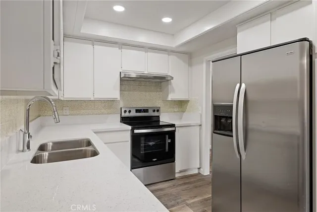 a kitchen with stainless steel appliances a refrigerator sink and stove
