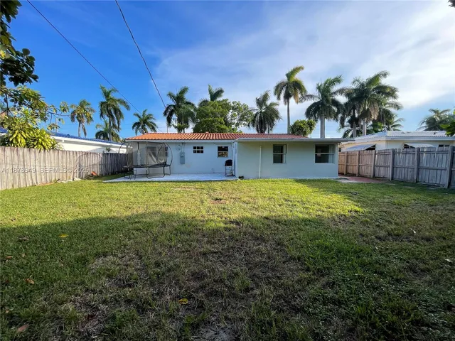 a view of a house with a yard and potted plants