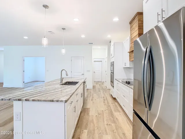 an aerial view of residential houses with outdoor space and trees