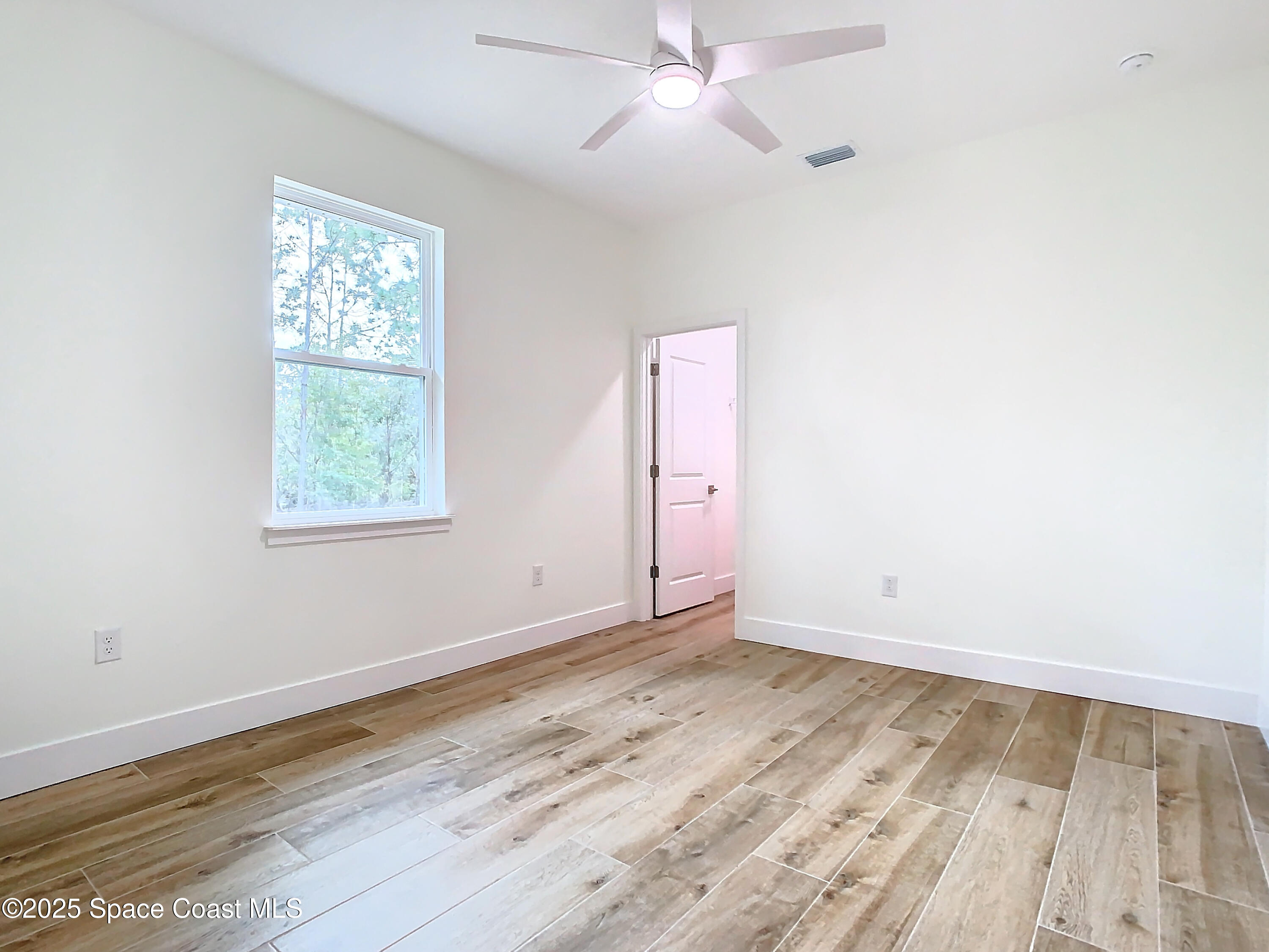 6110 Brabrook Avenue Grant, FL 32949 - Photo 25 of 85 an empty room with wooden floor fan and windows