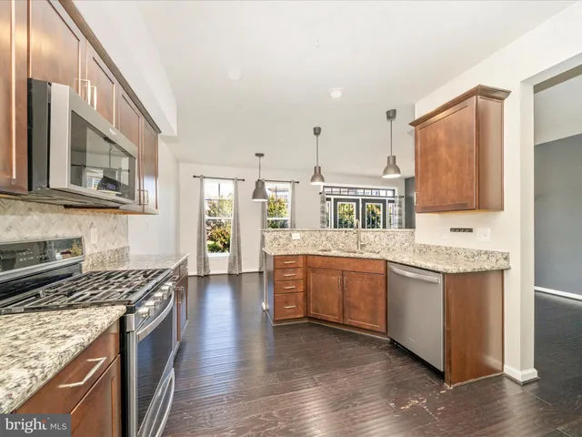 a kitchen with stainless steel appliances granite countertop a stove and cabinets