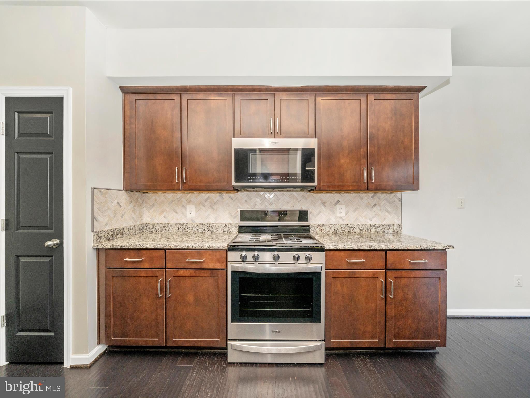5880 Imperial Drive Frederick, MD 21703 - Photo 25 of 54 a kitchen with granite countertop a stove microwave and sink