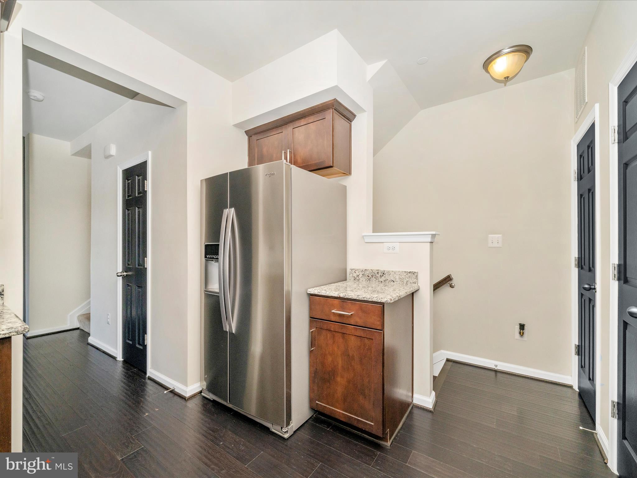 5880 Imperial Drive Frederick, MD 21703 - Photo 26 of 54 a kitchen with a refrigerator a stove and a microwave oven with wooden floor