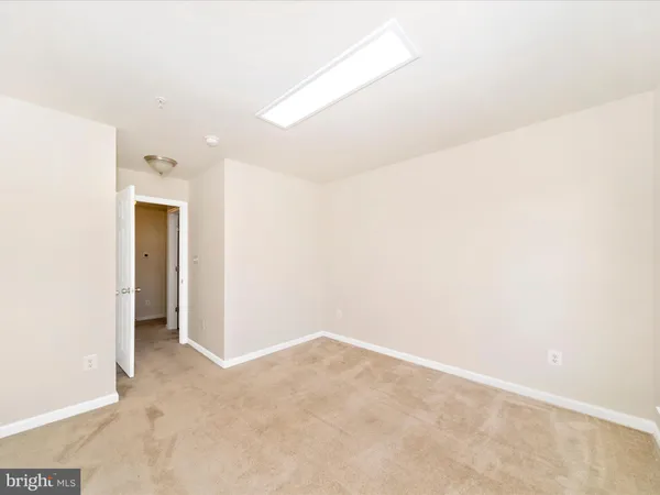 an empty room with windows and ceiling fan